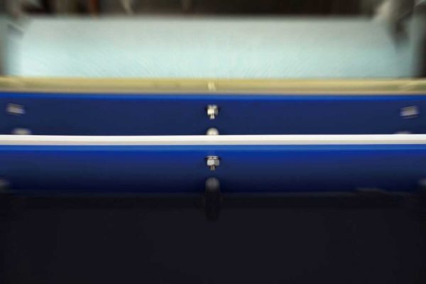 アンベル洗浄段階②削ぎ落とす　「2段階のスクレイパーが残渣、汚れを除去します。ベルトとスクレイパーの接触を常に等加重に保つことで削ぎ落としのムラを防ぎます。除去された残渣はスクレイパーBOXに収納されるので簡単に交換洗浄が可能です。」